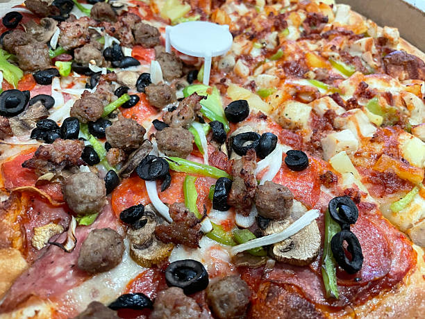 istock close up of half hawaiian and half combo pizza 2208048353