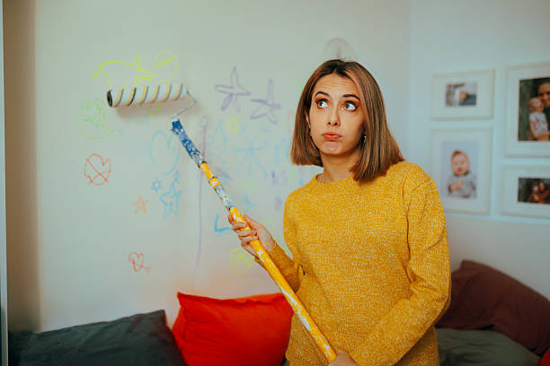 istock Tired Mother Painting the Walls After Her Kids Scribbled on Them 2208049943