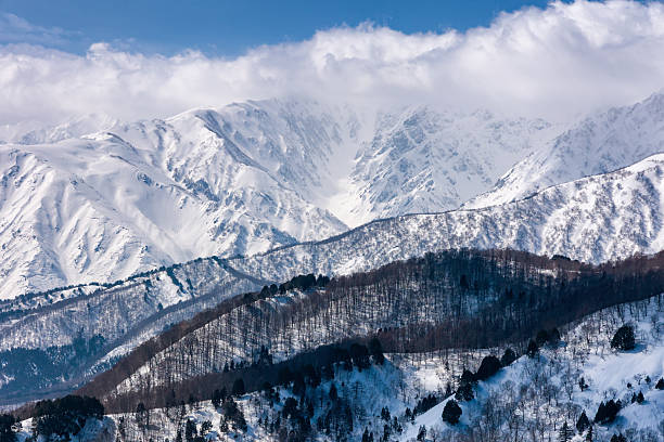 istock Towering snow covered mountain peaks and bare trees in front. Alpine landscape 2208050752