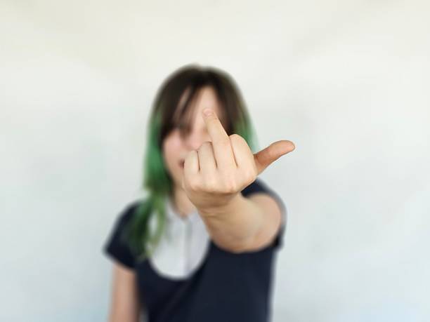 istock Schoolgirl in school uniform middle finger, indecently tensely back off. Aggression of teenagers emotions evil concept 2208057528