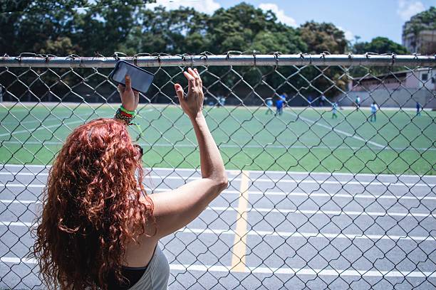 Soccer mom clapping her son playing a soccer match