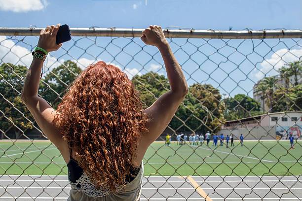 istock Soccer mom enthusiastically supporting her child's team from the sidelines 2208061874