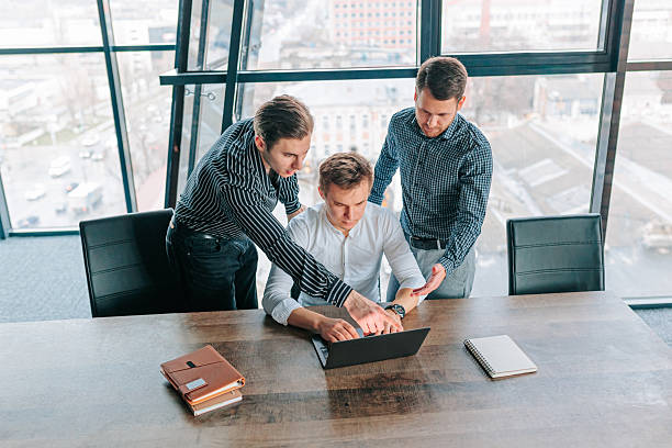 istock Young professionals collaborate in modern office setting on important project with focus on laptops and teamwork 2208063316