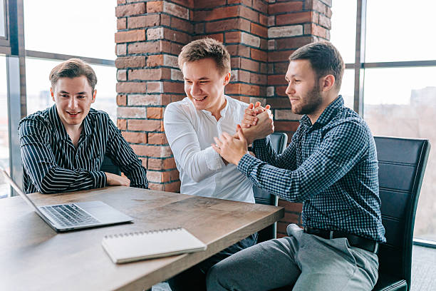istock Colleagues celebrate their success with a toast while working on a laptop in a modern office environment during the day 2208063321