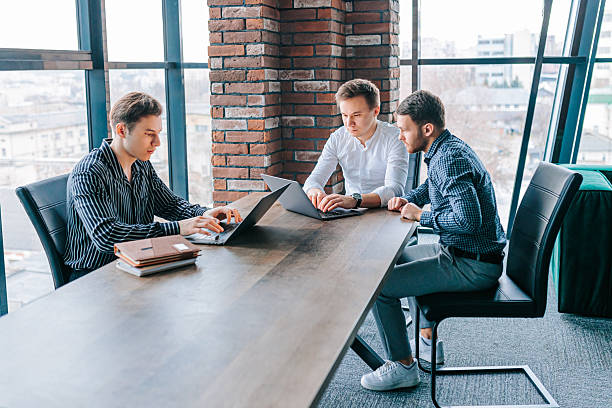 istock Young professionals collaborate on innovative ideas with mentor in modern office environment 2208063327