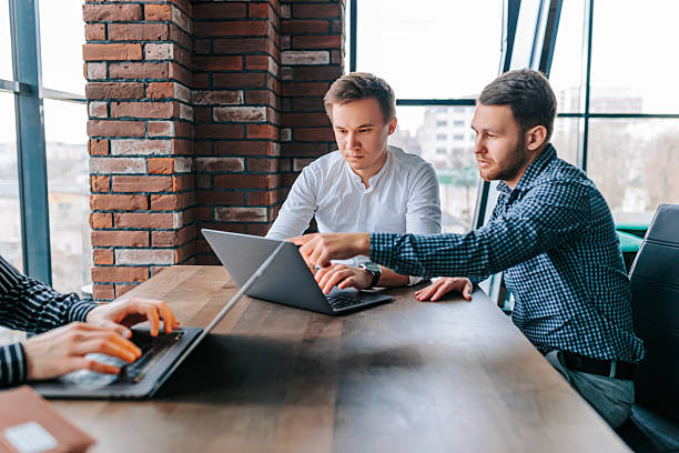 istock Young professionals collaborate in a modern workspace while receiving guidance from their mentor during a productive training session 2208063363