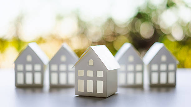 istock White paper house model on table, blur nature background, a symbol for construction , ecology, loan, mortgage, property or home. 2208064232