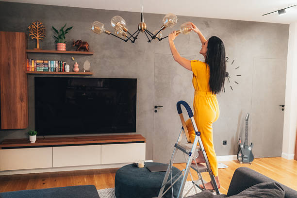 istock Woman Changing a Light Bulb in a Cozy Room 2208065111