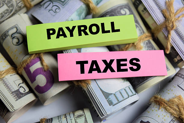 istock Concept Payroll Taxes on sticky notes on a wooden table with dollar bills 2208065370