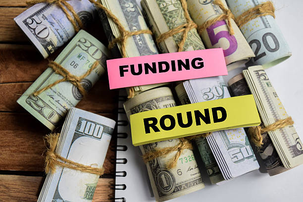 istock Concept Funding Round on sticky notes on a wooden table with dollar bills 2208065380