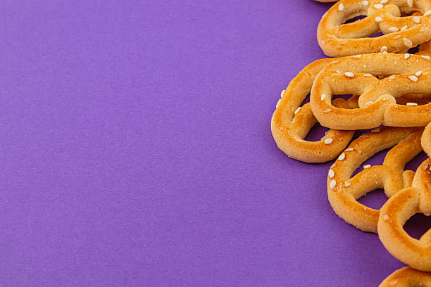 istock Pretzels scattered on a vibrant purple background for a fun snack display 2208067674