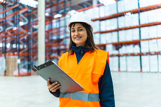 istock Female supervisor smiling and holding clipboard in logistics warehouse 2208068596