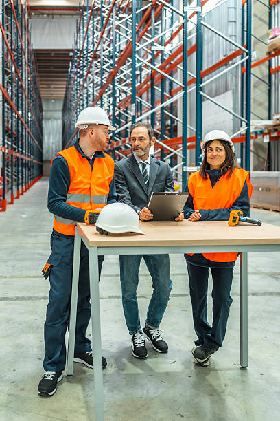 istock Warehouse workers and manager discussing logistics in large distribution center 2208068949