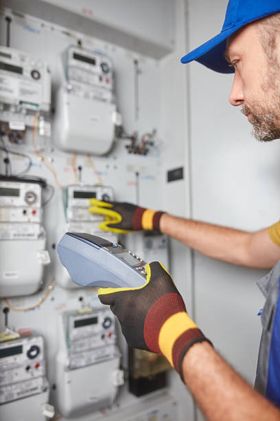 istock Technician reading consumption and charging on a wireless electricity power meter station in a building. 2208069051