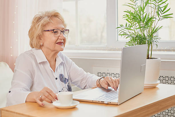 istock aged woman in glasses working at laptop 2208069603