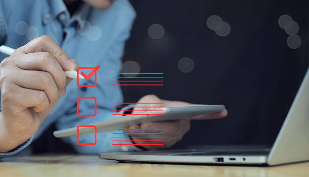 istock Businessman making correct sign mark on checkboxes to approve corporate project for business project approval concept.businessman using smartphone to do online survey, 2208070035
