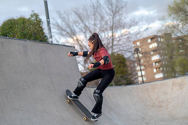 Young female skateboarder performing trick in skate park
