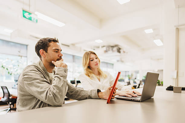istock Diverse coworkers working together at a shared desk in a creative workspace 2208071192