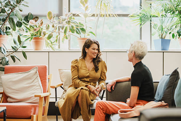 istock Diverse professional women sharing a joyful conversation in a modern lounge 2208071198