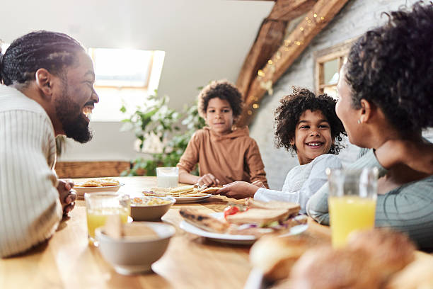istock Happy black parents and their kids talking during breakfast. 2208071937