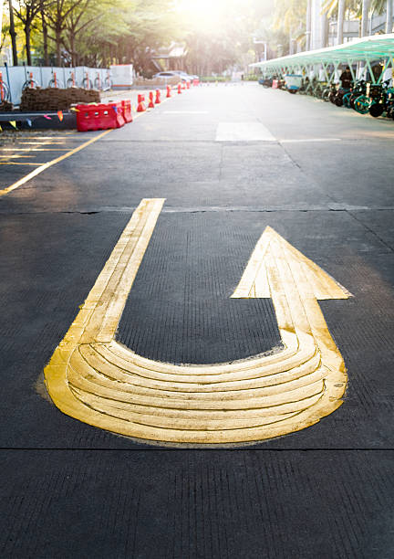 Yellow U-Turn arrow on concrete road