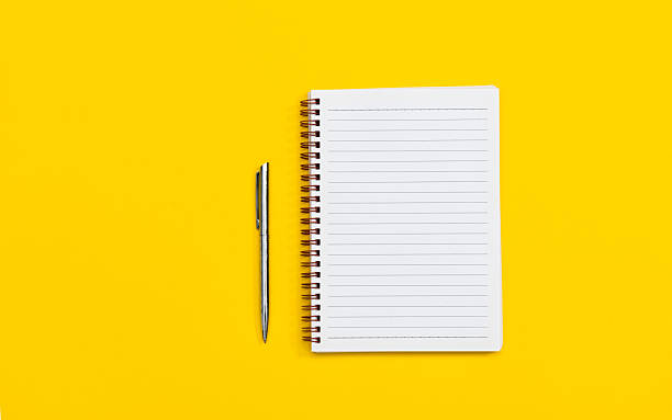 istock Spiral notebook and pen on yellow background 2208072743