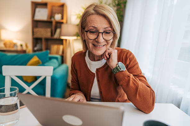 istock Senior adult woman working from home using laptop computer 2208073000