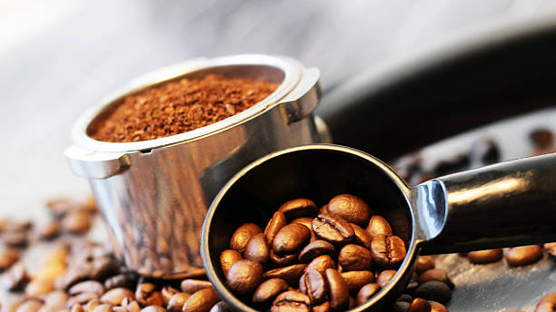 istock Coffee beans in a spoon and ground coffee in a horn 2208073628