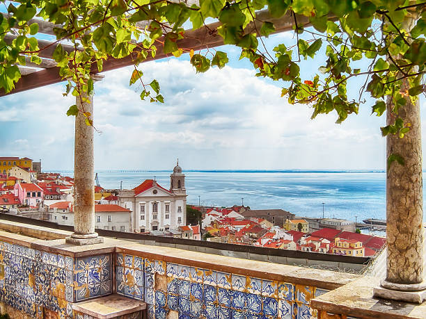 лиссабон, португалия. miradouro de santa luzia belvedere, терраса или смотровая площадка. вид на крыши алфамы, церковь санто-эстевао и устье реки тежу. - португалия стоковые фото и изображения