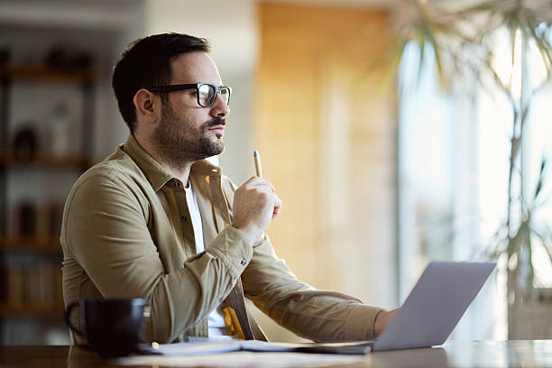 istock Thoughtful male entrepreneur working on laptop at home. 2208076689