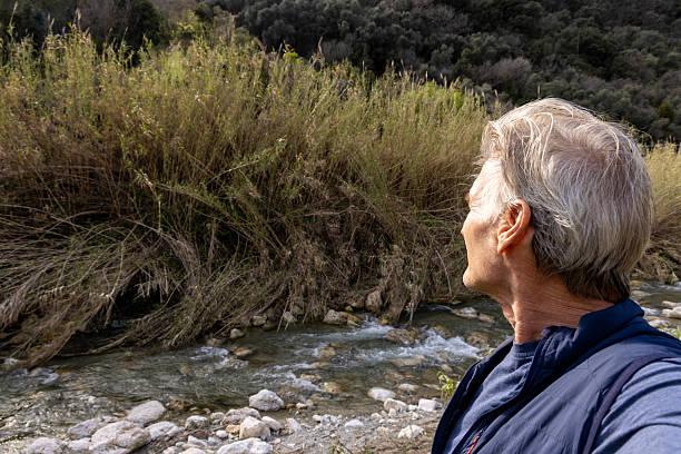Profile view of mature man on riverbank in springtime, Liguria