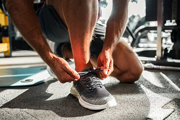 istock Athlete Tying Sneakers Preparing for Workout in Gym Setting 2208077300