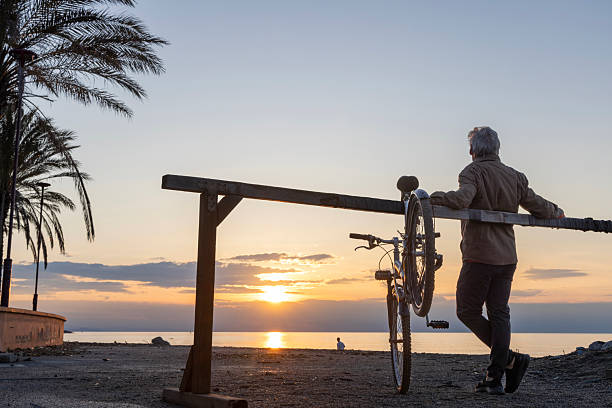 Mature man pauses by water's edge, Liguria