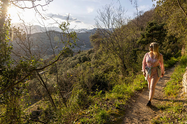 istock Mature woman  walks on pathway above hills in springtime 2208078506
