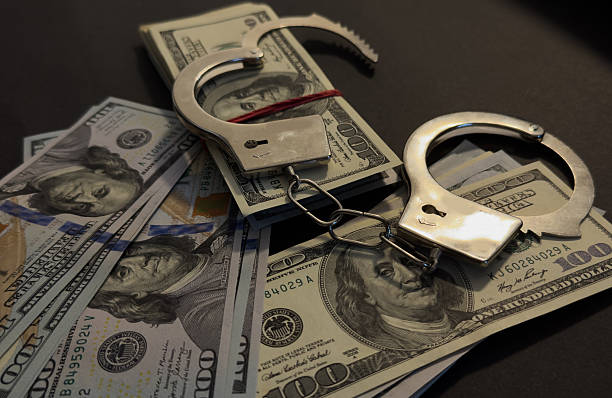 istock Handcuffs on 100 Bills on Concrete Floor for Crime 2208078515