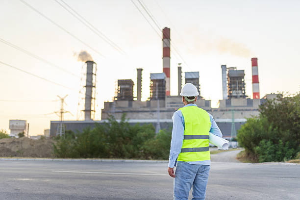 istock Engineer walking towards power plant holding blueprints 2208078735