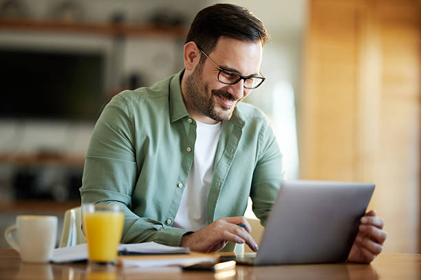 istock Smiling businessman working on laptop at home. 2208078816