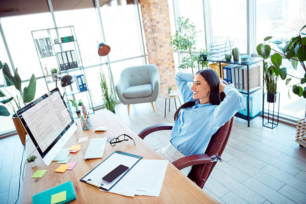 istock Young professional woman relaxing in modern office surrounded by a productive workspace with natural light and vibrant plants 2208081316