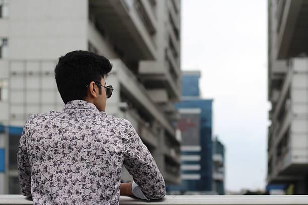 Back view of a male artist reflecting and standing by the sea, expressing reflection, inspiration, and creativity. Concept of motivation, lifestyle, and connection with nature.