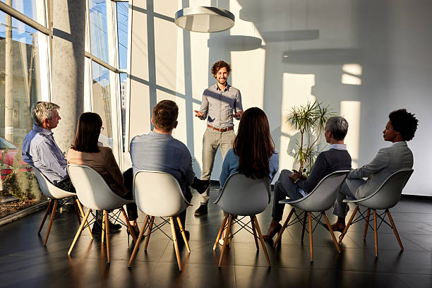 istock Happy male coach talking on a group therapy in the office. 2208081850