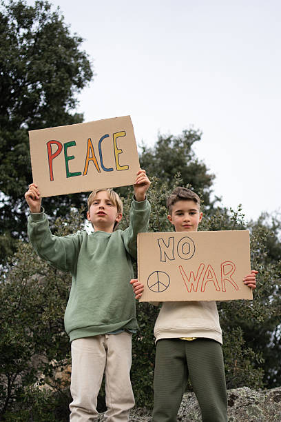 istock Two kids protesting for peace and against war holding cardboard signs 2208081921