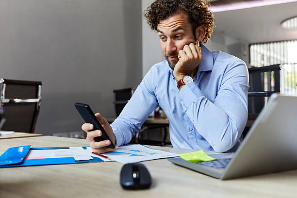 istock Young businessman using mobile phone in the office. 2208082002