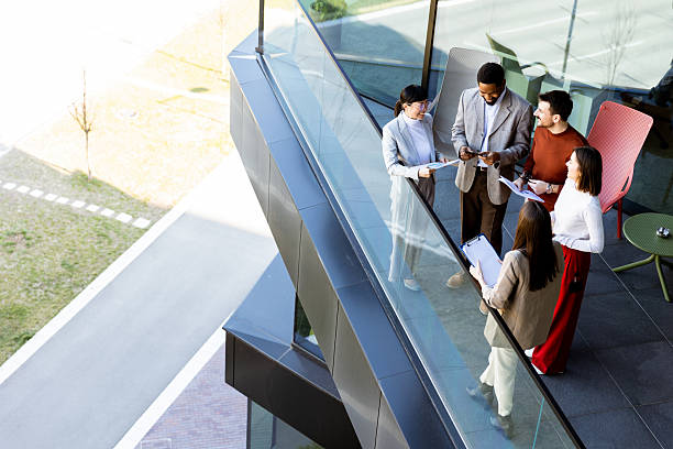 istock Group of professionals collaborating on project details in modern office space during sunny day 2208084327