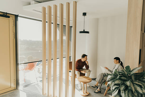 Engaging conversation unfolds inside a modern, stylish lounge with natural light filtering through