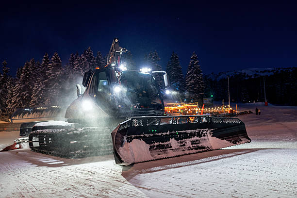 istock Snow grooming machine working at night on a snowy mountainside 2208084714