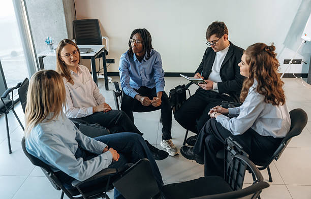 istock Sitting and talking. People are in group psychological support room together 2208084715