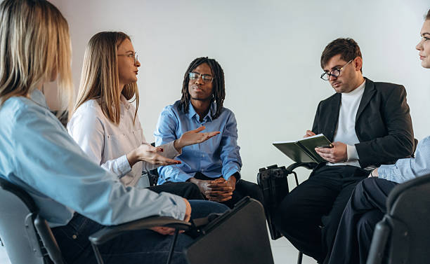 istock Therapist is with notepad. People are in group psychological support room together 2208084814