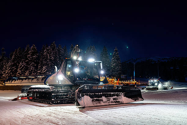 istock Snow grooming machines operating at night on a mountain slope 2208085253
