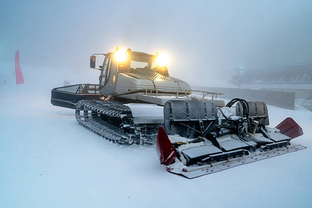 istock Snow grooming machine operating on a misty ski slope in winter evening 2208085368
