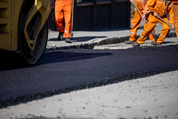 istock Construction workers laying asphalt on a road during daytime in an urban area 2208086178